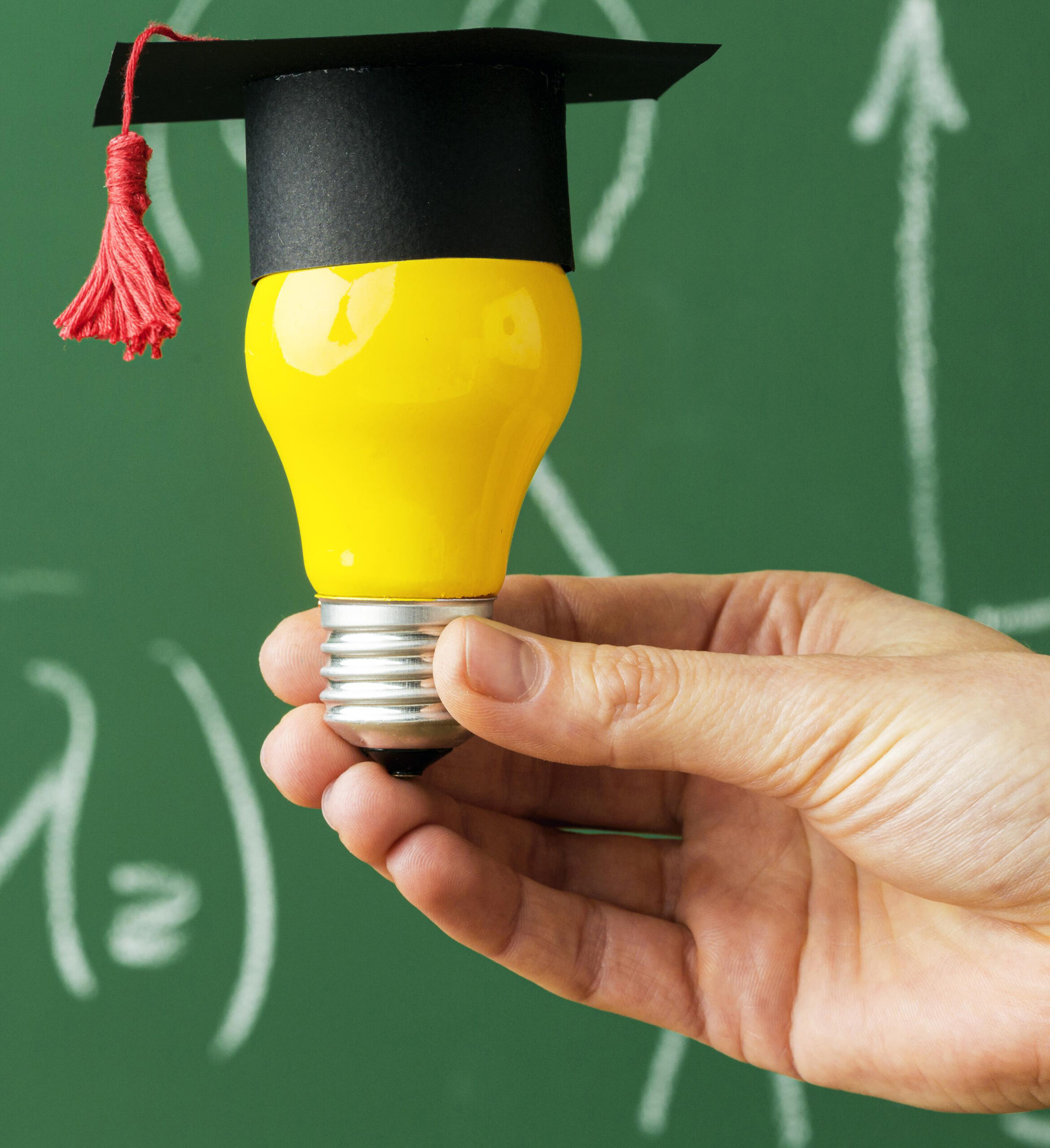 person-holding-lightbulb-with-academic-cap